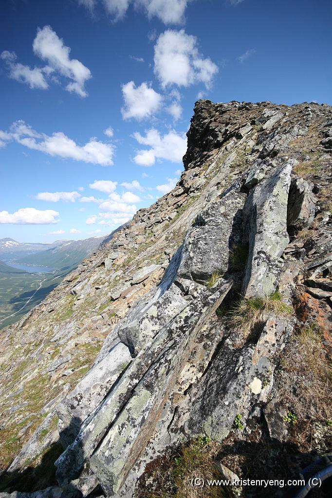 IMG_0074.JPG - Ryggen mot toppen. Den nordlige siden av fjellryggen inneholder flere spektakulære skrenter og stup - som her. Bak og til venstre ses sørligste del av Sørbotn.