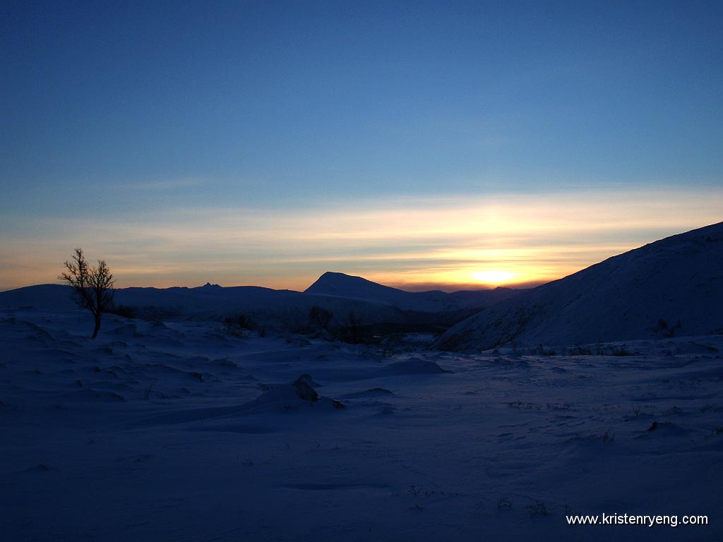 PB130014.jpg - Fra Finnvikdalen. Utsikt mot Tromsdalstinden og solen som jobber seg opp på himmelen.