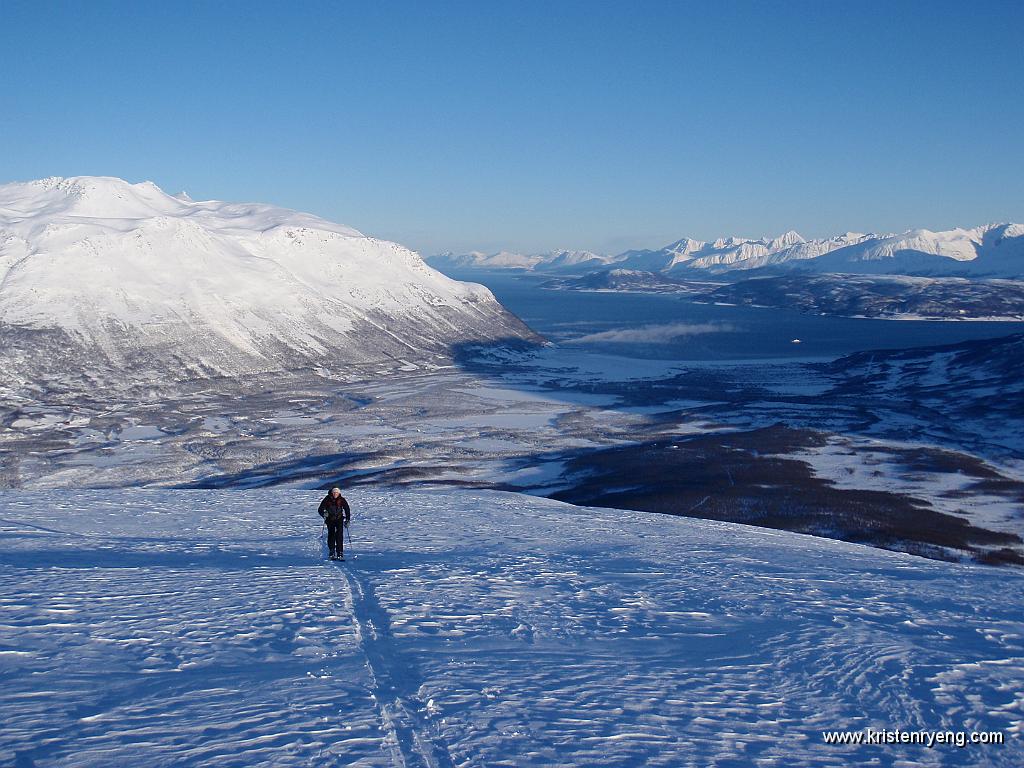 P2200127.JPG - Eirik på vei opp mot Stormheimfjellet. Ullsfjord fergen som traffikerer mellom Breivikeidet og Svensby ses bak til høyre i bildet.